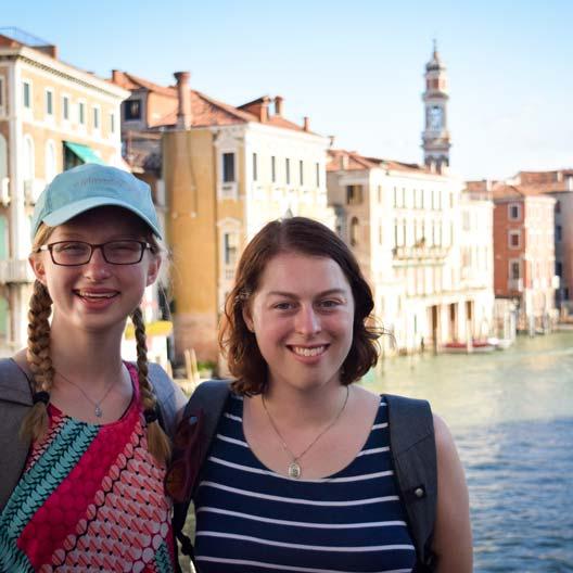 两个学生微笑着，背景是威尼斯的运河